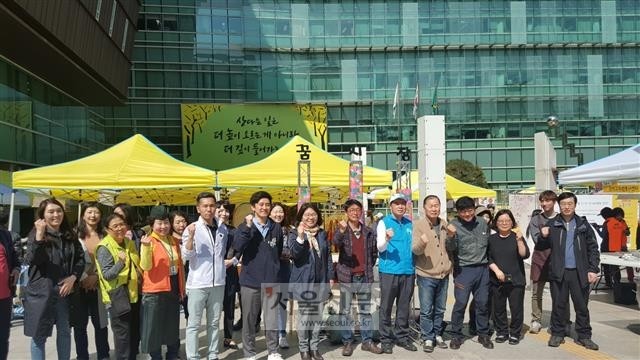 12일 서울 관악구청 앞마당에서 열린 꿈시장 개장식에서 사회적경제기업 참여자들이 파이팅을 외치며 기념사진을 찍고 있다.