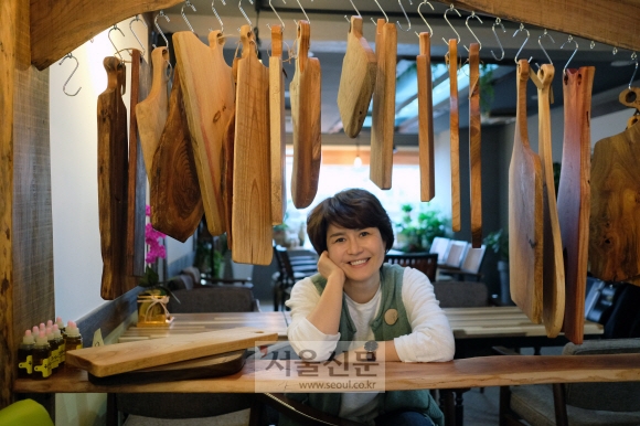 목공문화발전소 나무푸조&꾸보기 공방 대표 구순복(42)씨가 자신이 만든 나무도마 작품을 배경으로 포즈를 취하고 있다.