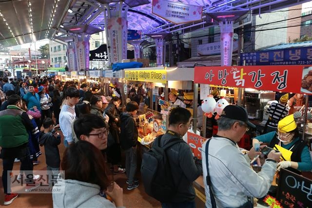 지난달 개장한 제주 동문시장 야시장이 밤마다 밀려드는 관광객들로 북새통을 이루고 있다. 다양한 먹거리가 입소문을 타면서 단번에 제주 야간관광 명소가 됐다. 제주 황경근 기자 kkhwang@seoul.co.kr