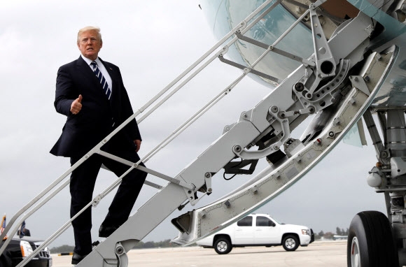 도널드 트럼프 미국 대통령이 22일(현지시간) 플로리다주 팜비치공항에서 워싱턴DC의 백악관으로 향하는 전용기에 올라타면서 엄지손가락을 치켜세우고 있다.  팜비치 로이터 연합뉴스