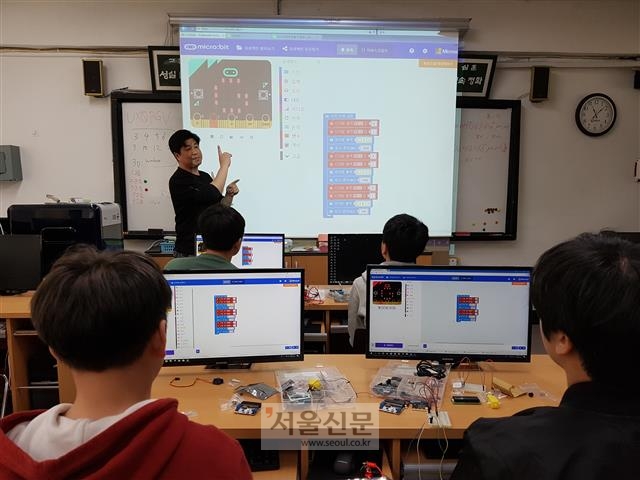 지난 21일 서울 은평구 충암중 컴퓨터실에서 ‘방과후 학교’의 코딩 수업에 참여한 학생들이 임현준 정보 교사의 설명을 듣고 있다. 학생들은 이날 코딩 교구인 ‘마이크로 비트’를 활용해 신호등 체계를 직접 만들었다.