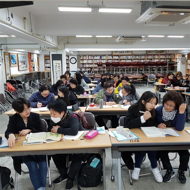 지난 7일 서울 마포구 일성여중 교실에서 서울여중 학생들이 어머니나 할머니뻘인 만학도들의 공부를 돕고 있다. 서울교육청 제공