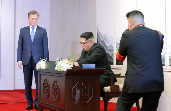남북정상회담이 열린 27일 김정은 북한 국무위원장이 평화의 집에 입장해 방명록에 서명을 하고 있다.  안주영 기자 jya@seoul.co.kr