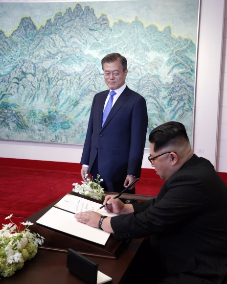 남북정상회담이 열린 27일 문재인 대통령이 평화의 집에서 김정은 북한 국무위원장이 방명록에 서명을 하고 있는 모습을 지켜보고 있다. 안주영 기자 jya@seoul.co.kr