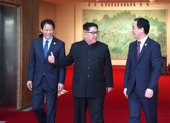 김정은(가운데) 북한 국무위원장이 27일 오전 남북정상회담 후 평화의 집 1층으로 내려와 조명균(오른쪽) 통일부 장관과 대화를 하며 나서고 있다.   안주영 기자 jya@seoul.co.kr