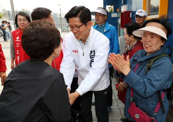 김문수(가운데) 자유한국당 서울시장 후보가 청량리역을 방문해 시민과 손잡고 인사하고 있다.  연합뉴스