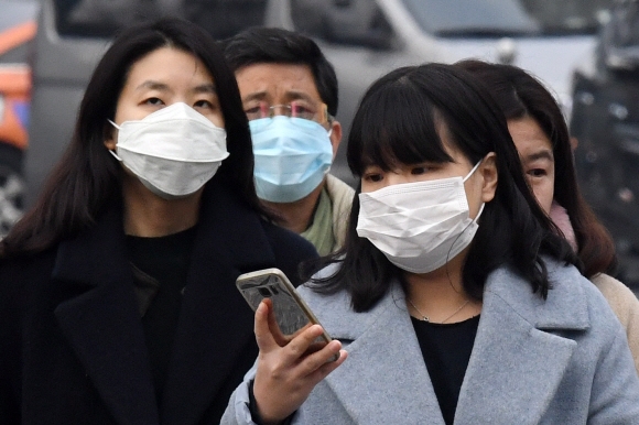 미세먼지 농도가 며칠째 나쁨을 기록하고 있는 가운데 17일 오전 서울 종로구 광화문에서 시민들이 마스크를 쓴 채 길을 걷고 있다. 2018.1.17 손형준 기자 boltagoo@seoul.co.kr