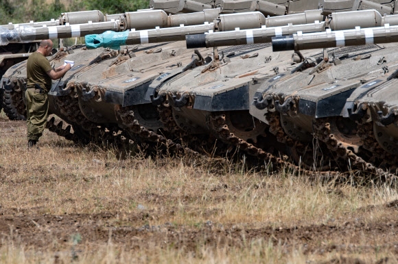 이스라엘 군인이 9일(현지시간) 시리아 골란고원에 배치한 탱크를 점검하고 있다. 도널드 트럼프 미국 대통령이 지난 8일 이란 핵합의를 파기한 이후 이란과 이스라엘이 공격을 주고받으면서 이 지역에 긴장감이 고조되고 있다.  골란고원 신화 연합뉴스