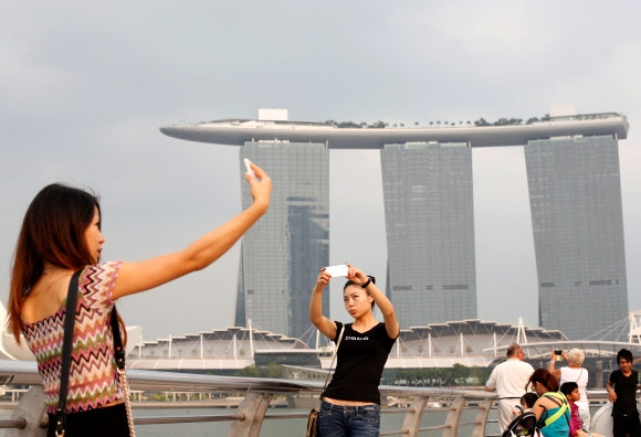 역사적인 북미정상회담이 다음달 12일 싱가포르에서 열리는 가운데 마리나베이 샌즈 호텔 등이 개최 장소로 거론되고 있다. 싱가포르 마리나베이 샌즈 호텔에서 사진을 찍고 있는 관광객들. 2014.3.4 [로이터=연합뉴스]
