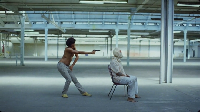 차일디쉬 감비노 ‘이것이 미국이다’(This is America) 뮤직비디오의 한 장면. 차일디쉬 감비노가 직접 뮤직비디오에 출연해 ‘짐 크로’를 떠올리게 하는 자세로 방아쇠를 당기고 있다.