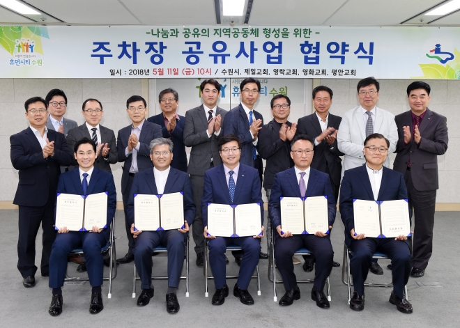 11일 염태영 수원시장(앞줄 가운데)과 교회 관계자들이 주차장 나눔 협약을 체결한후 기념촬영을 하고 있다. 수원시 제공