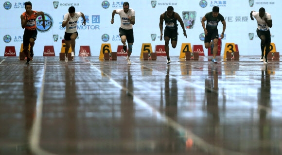 12일 중국 상하이 다이아몬드리그 남자 100m 경기에 나선 선수들이 트랙이 흠뻑 젖은 상태에서 출발하고 있다. 상하이 AP 연합뉴스