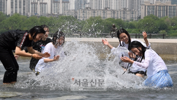 초여름 날씨를 보인 15일 오후 서울 여의도 물빛광장을 찾은 학생들이 물놀이를 하며 더위를 식히고 있다. 2018.5.15  도준석 기자 pado@seoul.co.kr