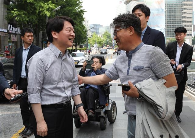여야 3당 서울시장 후보들이 15일 유권자들을 만나 지지를 호소했다. 안철수 바른미래당 후보가 청계광장에서 한 시민의 응원을 받고 있다.  뉴스1