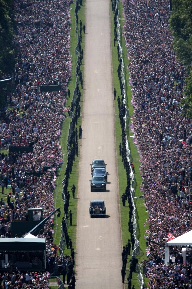 해리 왕자와 마클을 태운 차량이 하객들의 축하 인사를 받으며 식장을 떠나고 있다. 런던 AP 연합뉴스