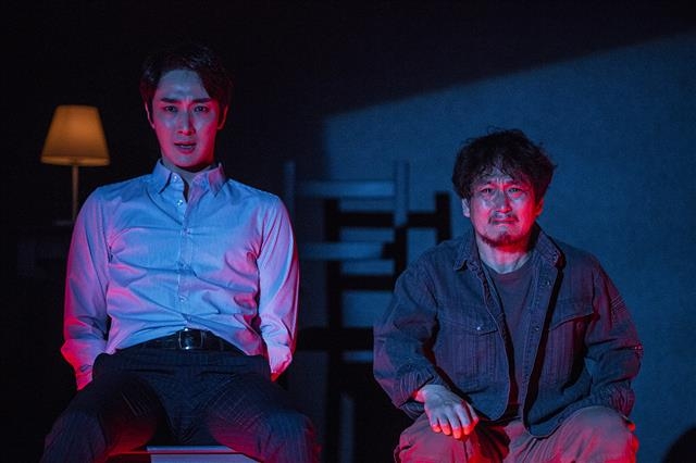 연극 ‘킬롤로지’에서 데이비의 아버지 알란(김수현·오른쪽)이 온라인게임 개발자 폴(김승대)을 의자에 결박한 후 데이비가 살해되는 모습이 촬영된 DVD 화면을 보며 오열하고 있다. 연극열전 제공