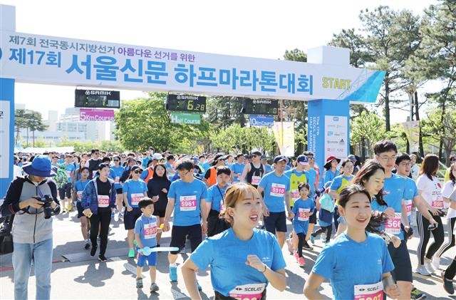 지난 19일 서울신문 하프마라톤 대회 참가자들이 6·13 지방선거를 홍보하는 플래카드 아래로 코스를 달리고 있다. 중앙선관위 제공