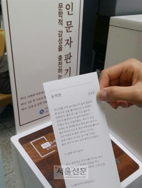 28일 안양시청 민원실을 방문한 한 민원인이 인문자판기에서 기다리는 동안 읽을 문학작품을 출력하고 있다.