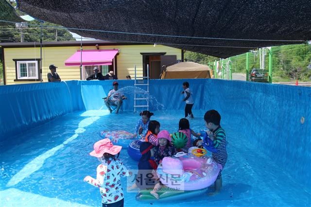 지난달 26일 대구 안심마을 공동체의 공동육아 협동조합인 ‘동동 어린이집’ 아빠들이 만든 수영장에서 아이들이 신나게 물놀이를 하고 있다.