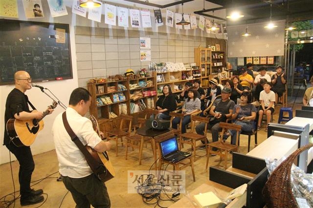 안심마을 공동체 아빠들의 아지트인 카페 ‘땅과 사람이야기’에서 작은 음악회가 열리고 있다.