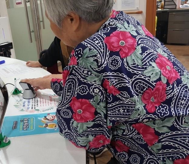 서울 관악구 치매안심센터에서 한 노인이 지문을 등록하고 있다.  관악구 제공