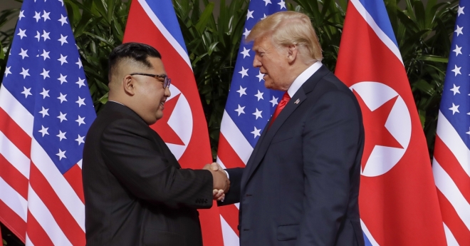 도널드 트럼프(오른쪽) 미국 대통령과 김정은 북한 국무위원장이 정상회담을 위해 12일 싱가포르 센토사섬 카펠라 호텔에서 만나 악수하고 있다. AP 연합뉴스