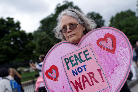 미국 워싱턴 백악관 주변에서 평화를 상징하는 푯말을 들고 있는 사람. 로이터 연합뉴스