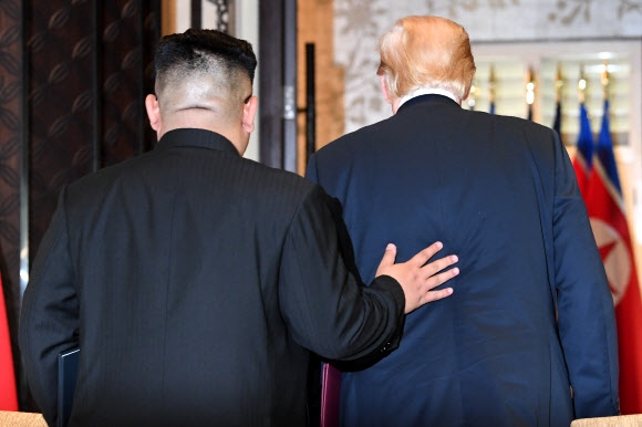 북·미 정상회담을 위해 싱가포르를 방문한 도널드 트럼프(오른쪽) 미국 대통령과 김정은(왼쪽) 북한 국무위원장이 12일 카펠라호텔에서 열린 정상회담 합의문 서명식을 마치고 이동하고 있다. 트럼프 대통령은 “(비핵화) 프로세스를 매우 빠르게 시작할 것”이라고 말했다. 김 위원장은 “세상은 아마 중대한 변화를 보게 될 것”이라고 밝혔다. 싱가포르 AFP 연합뉴스