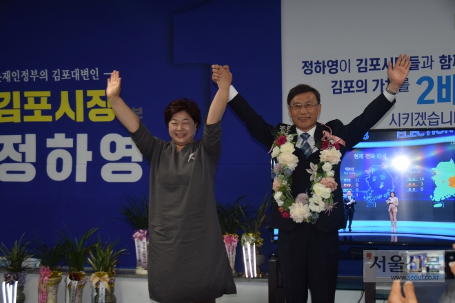 정하영(오른쪽) 김포시장 당선인이 당선이 확정된 뒤 부인 방혜란씨의 손을 치켜들며 기뻐하고 있다. 정하영 후보측 제공