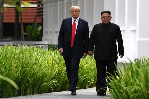 지난 12일 북·미 회담 후 함께 산책하는 김 위원장과 도널드 트럼프 미국 대통령. AFP 연합뉴스