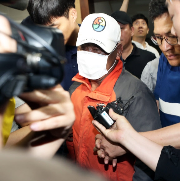 전북 군산시 장미동 한 주점에 불을 지른 혐의로 긴급체포된 이모(55)씨가 18일 새벽 병원 치료를 받기 위해 군산경찰서를 나가고 있는 모습. 연합뉴스