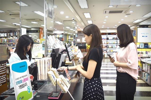 서울 노원구에 있는 한 서점에서 구민이 지역화폐 ‘노원(NW)’을 사용해 결제하고 있다. 노원구 제공