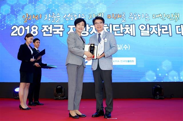 정원오(오른쪽) 서울 성동구청장이 지난 20일 세종시 정부세종컨벤션센터 대연회장에서 열린 ‘2018 전국 지방자치단체 일자리대상’에서 최우수상을 받은 뒤 김영주(왼쪽) 고용노동부 장관과 기념 촬영을 하고 있다.  성동구 제공