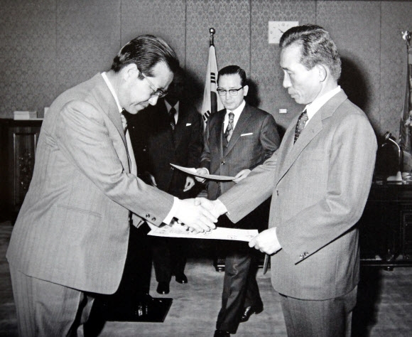 김종필 전 총리가 1974년 당시 박정희(오른쪽) 대통령으로부터 국무총리 임명장을 전달받는 모습.  연합뉴스
