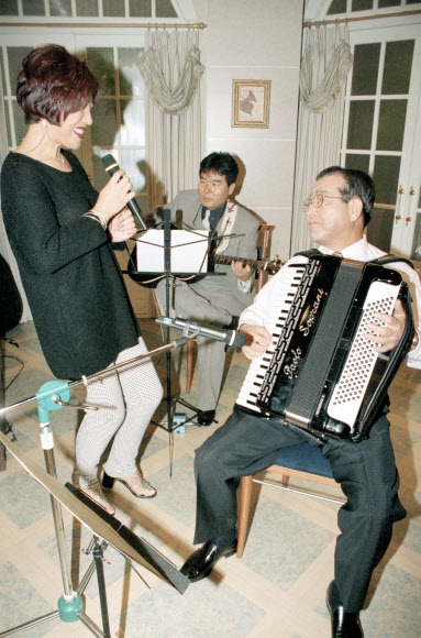 김종필(오른쪽) 당시 자유민주연합 총재가 1997년 9월 3일 SBS 특별생방송 ‘대통령 후보와 함께’ 프로그램에 출연해 가수 노사연(왼쪽)씨와 함께 가요 ‘만남’을 아코디언으로 연주하고 있다. 연합뉴스