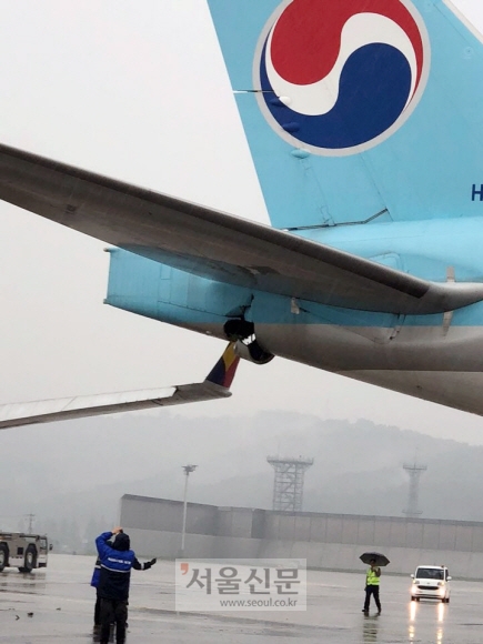 26일 오전 서울 강서구 김포공항 국제선 주기장에서 이륙 전 탑승 게이트로 이동하던 아시아나항공 OZ3355편의 날개와 대한항공 KE2725편의 후미 꼬리 부분이 부딪히는 접촉사고가 발생했다. 2018. 6. 26 독자 제공