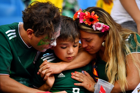 3일 러시아월드컵 16강전 브라질-멕시코 경기가 열린 사마라 아레나 관중석에서 멕시코가 8강 진출에 실패하자 멕시코의 한 ‘축구 가족’이 낙담하고 있다.  사마라 로이터 연합뉴스
