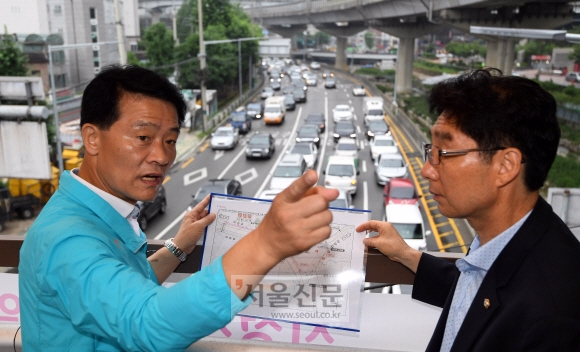 지난 5일 오전 서울 성북구 월곡역 인근 육교에서 이승로(왼쪽) 성북구청장이 주민과 상습 차량정체 문제에 대해 이야기하고 있다. 박윤슬 기자 seul@seoul.co.kr