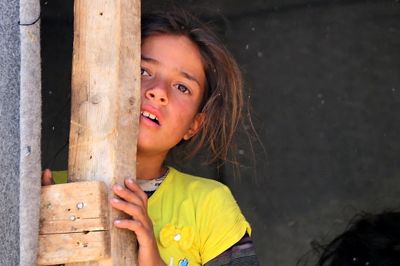 2011년 이후 7년째 계속되고 있는 시리아 내전으로 고향인 남부 다라를 탈출해 이스라엘 국경 지대의 쿠네이트라 난민 캠프에 살고 있는 한 소녀가 지난달 22일 자신을 촬영하고 있는 취재진을 바라보고 있다.  쿠네이트라 AFP 연합뉴스