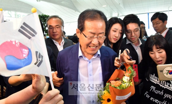 홍준표 전 자유한국당 대표가 11일 오후 인천국제공항을 통해 미국으로 출국 전 지지자들과 인사하고 있다. 2018.7.11. 안주영 기자 jya@seoul.co.kr