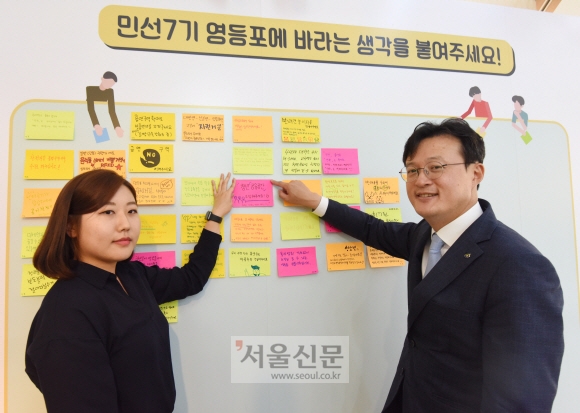 채현일 영등포구청장이 지난 10일 서울 영등포구 영등포동 영등포관광정보센터 안에 마련된 ‘영등포 1번가’ 오프라인 접수창구에서 주민과 함께 ‘청년 공간 조성’ 의견이 적힌 포스트잇을 벽에 붙인 뒤 기념촬영을 하고 있다.  최해국 선임기자 seaworld@seoul.co.kr