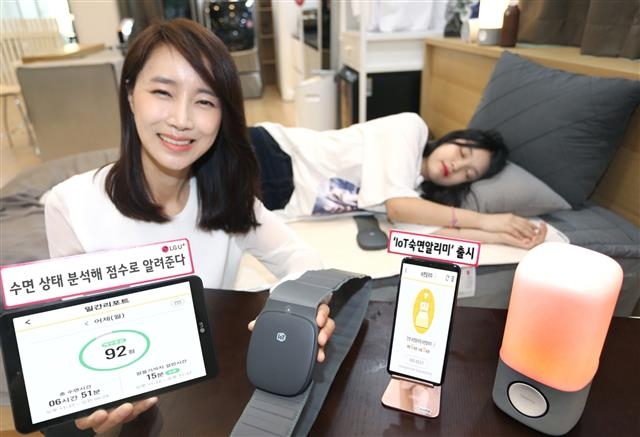 LG유플러스 모델들이 15일 수면 상태를 측정해 건강한 수면습관 형성을 도와주는 사물인터넷(IoT) 기기인 ‘IoT숙면알리미’를 소개하고 있다. 　 LG유플러스 제공