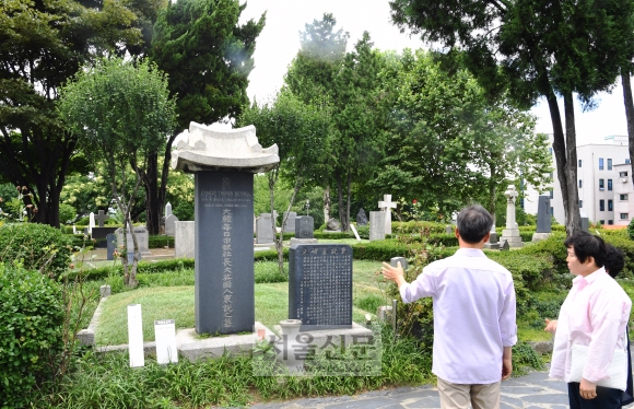 지난 6일 서울 합정동 양화진외국인선교사묘원을 찾은 참배객들이 대한매일신보 설립자 어니스트 토머스 베델의 묘지를 살펴보고 있다.  김명국 선임기자 daunso@seoul.co.kr
