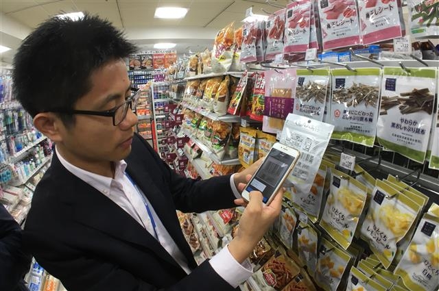 지난달 28일 도쿄 시나가와구 게이트시티오사키에 자리한 로손 편의점에서 한 손님이 무인 구매·결제 시스템인 ‘스마트폰페이’를 이용해 물건을 사고 있다. 　도쿄 손형준 기자 boltagoo@seoul.co.kr