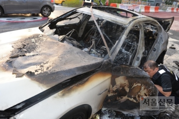 성남시 수정구 한 상가 앞 도로에 주차된 BMW 520d 승용차에서 불이 나 출동한 소방관들에 의해 진화됐다. 과학수사요원이 불탄 차량 내부를 살펴보고 있다. (경기재난안전본부 제공)