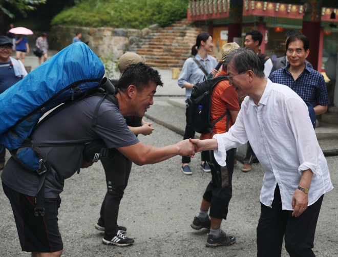 지난해 7월 31일, 취임 후 첫 여름휴가를 맞은 문재인 대통령이 오대산 상원사길을 걷다가 만난 시민과 악수를 나누고 있다.