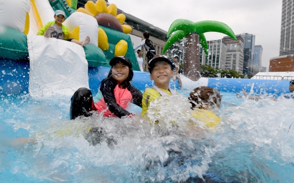 26일 서울광장에서 열린 ‘빗물축제’에서 아이들이 빗물놀이터에서 물놀이를 하며 더위를 식히고 있다. 빗물을 주제로 물놀이, 영화, 콘서트 등을 즐길 수 있는 이번 축제는 오는 28일까지 열린다. 2018.7.26   박지환기자 popocar@seoul.co.kr