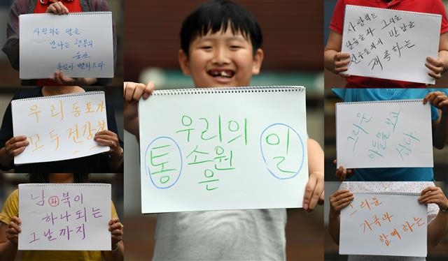 한 어린이가 ‘우리의 소원은 통일’이라고 적힌 스케치북을 들고 해맑게 웃고 있다. 서울신문 DB
