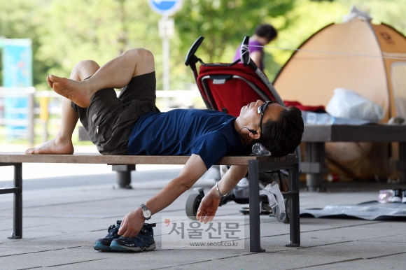 영등포구 여의도 한강공원을 찾은 한 시민이 마포대교 아래 그늘에 누워 휴식을 취하고 있다. 박윤슬 기자 seul@seoul.co.kr