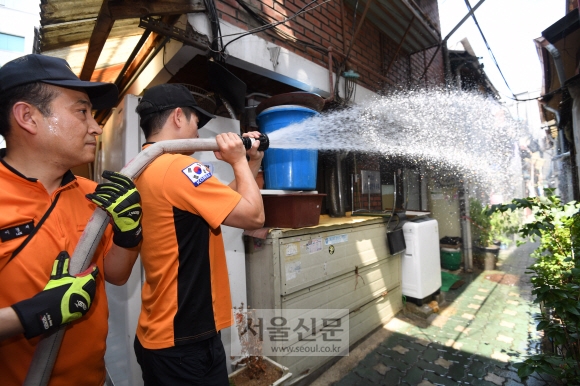 1일 서울 낮 최고기온이 39.6도를 기록했다. 서울의 기상관측 111년 사상 최고기온으로 종전 기록인 1994년 7월 24일의 38.4도보다 1.2도 높았다. 폭염이 쏟아진 이날 종로소방서 소방관들이 종로구 돈의동 쪽방촌에 물을 뿌리고 있다. 도준석 기자 pado@seoul.co.kr